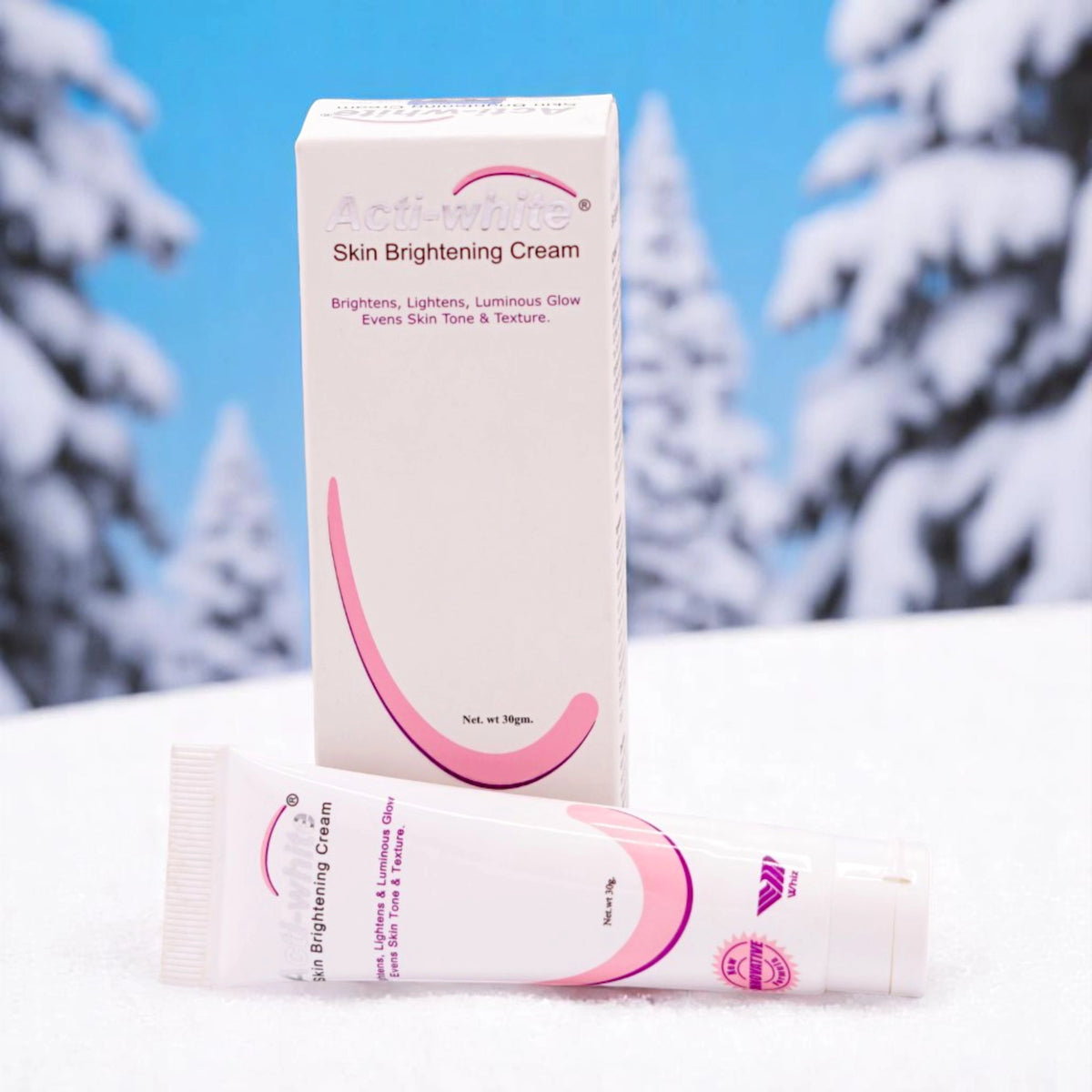 Actiwhite Skin Brightening Cream, 30g white tube with pink accents, and its matching white and pink box, set against a snowy background with pine trees.