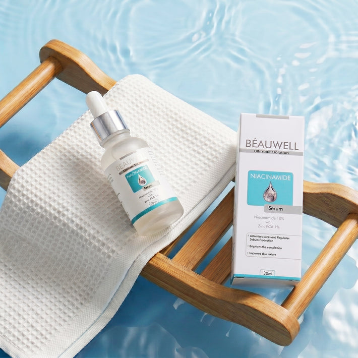 Beauwell Niacinamide Serum 10% with Zinc PCA 1% bottle and packaging on a wooden tray over water