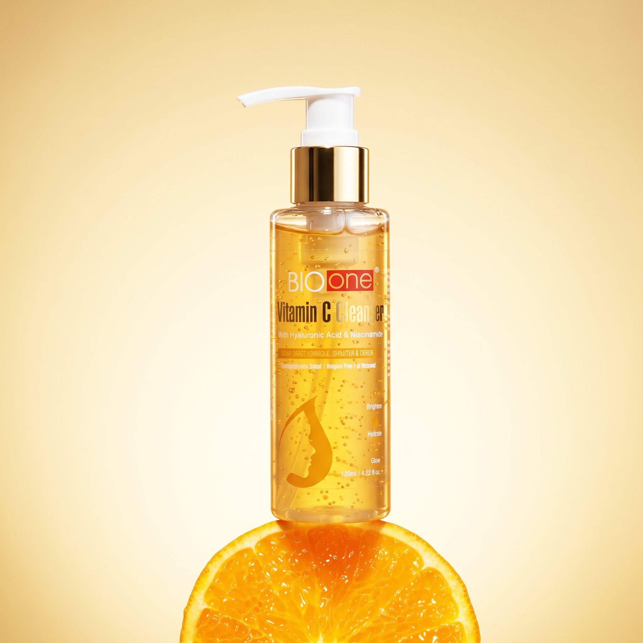 BIO ONE Vitamin C Cleanser pump bottle standing on a fresh orange slice.