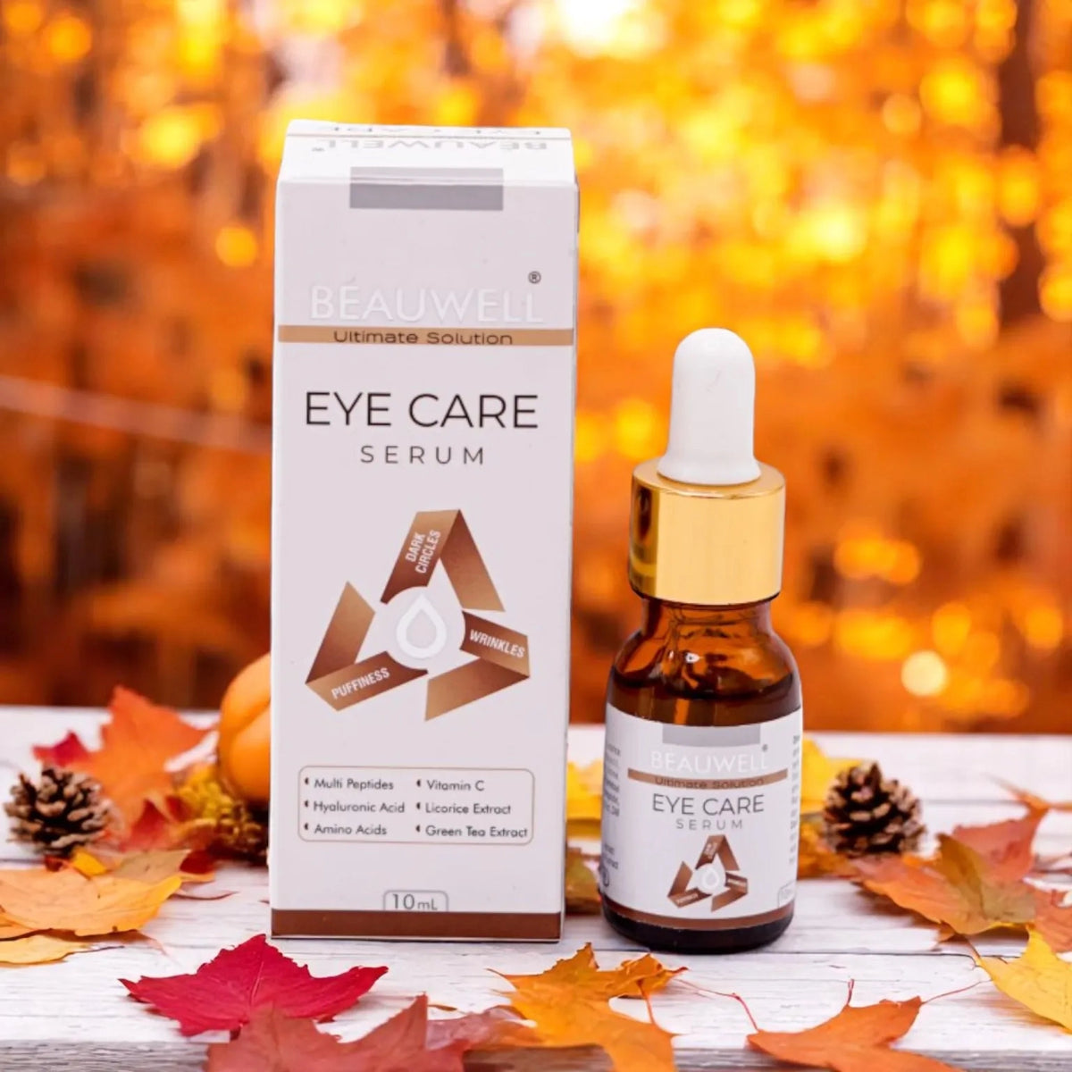 Beauwell Eye Care Serum bottle and outer box displayed on a bed of autumn leaves.