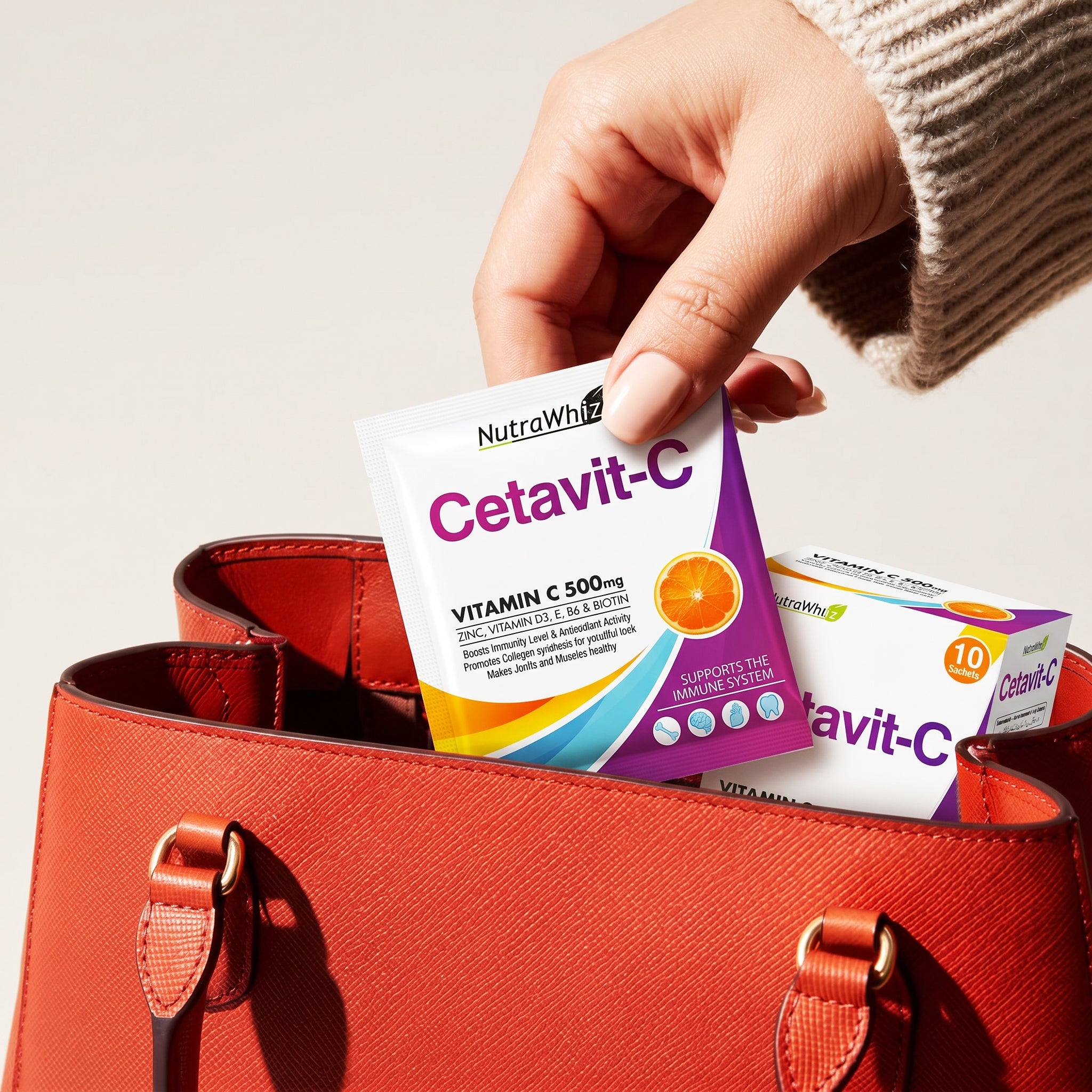 Hand placing a Nutra Whiz Cetavit-C Vitamin C 500mg sachet into a red leather handbag