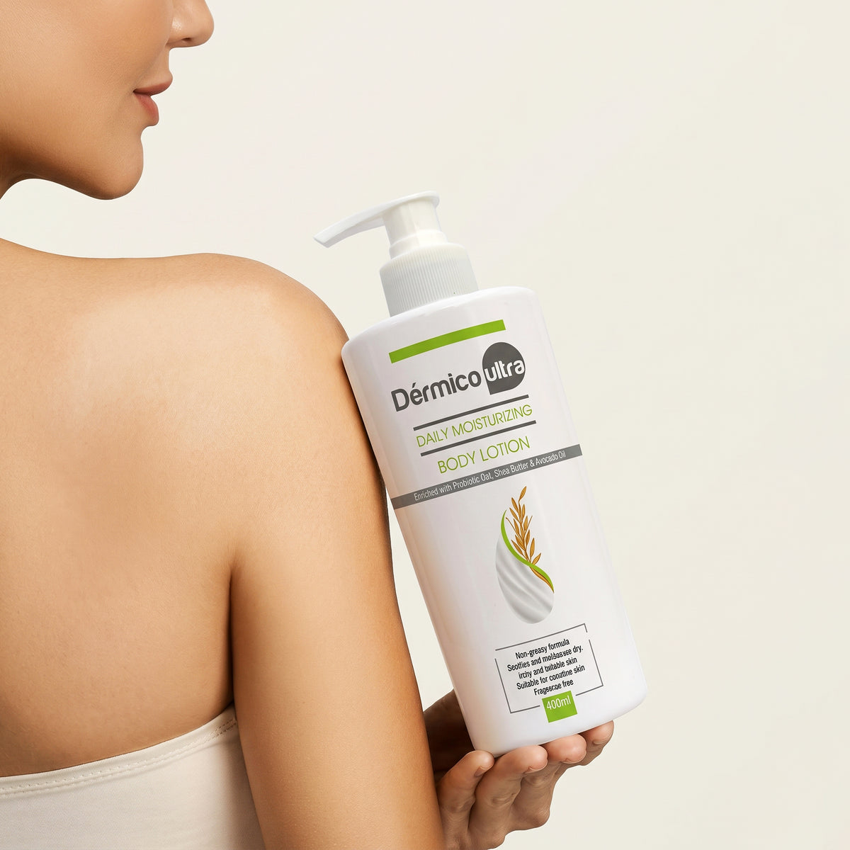 Woman holding a bottle of Dermico Ultra Daily Moisturizing Body Lotion against her shoulder