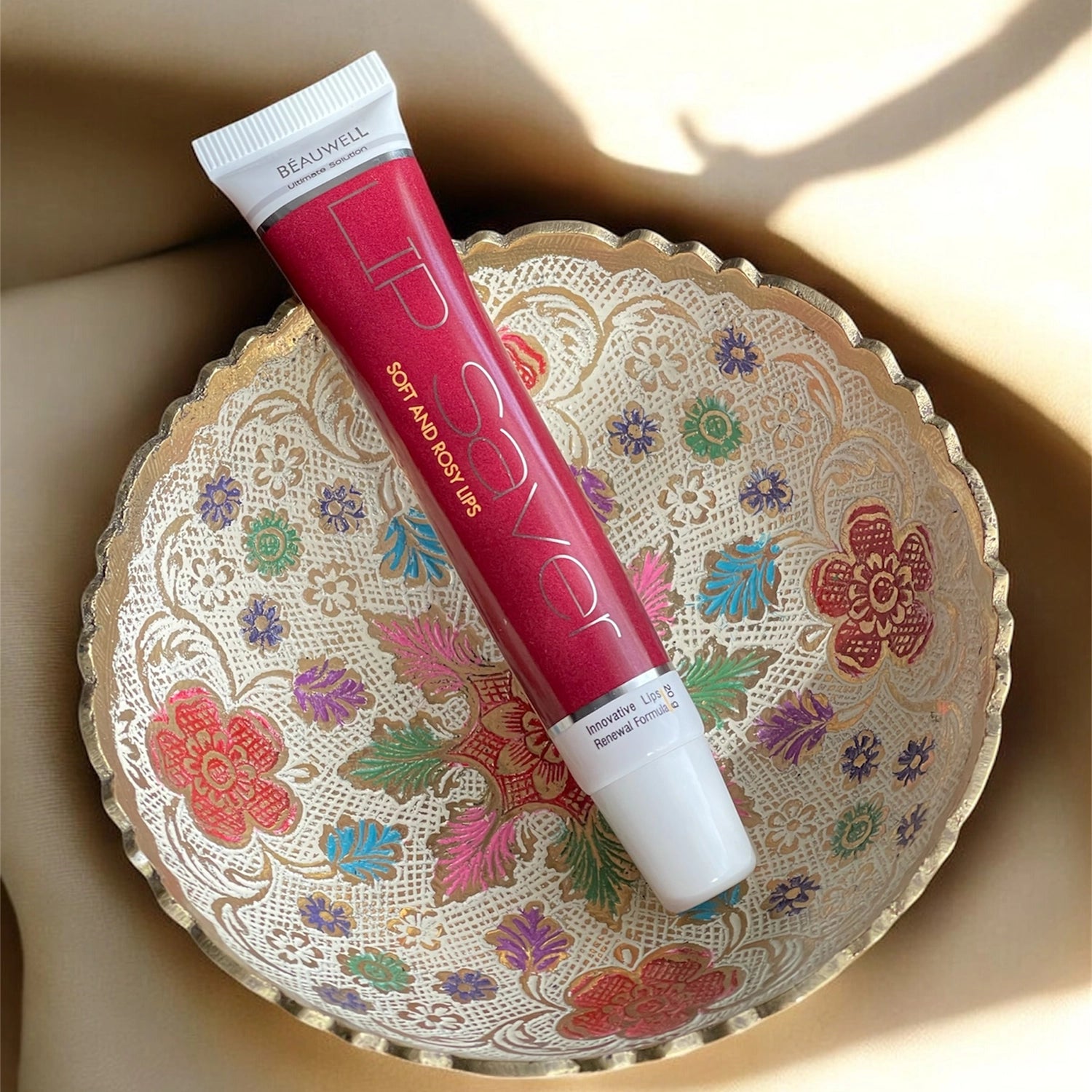 A close-up of a red and white tube of Beauwell Lip Saver cream, labeled 'Soft and Rosy Lips' and 'Innovative Lips Renewal Formula