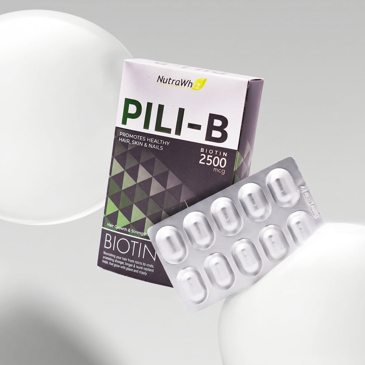 PILI-B Biotin 2500 mcg capsules packaging and blister pack displayed against a clean white background with abstract spheres