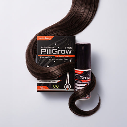 PiliGrow Hair Spray bottle and box displayed with a dramatic sweep of long, dark brown hair on a light gray background.