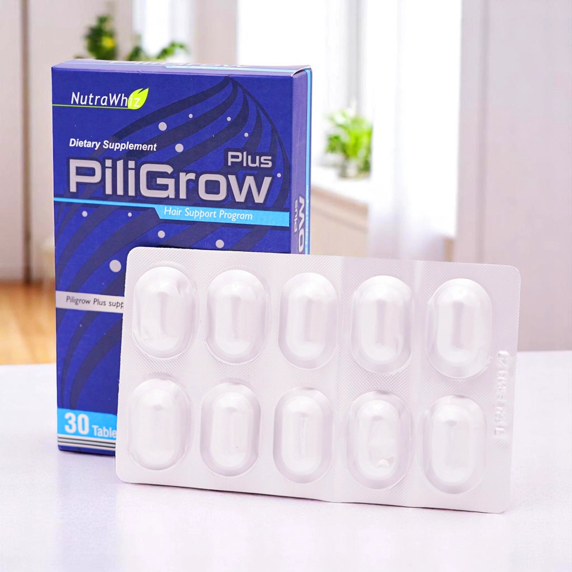 NutraWhiz PiliGrow Plus dietary supplement, with a blister pack of 30 tablets in front of its blue and white box.