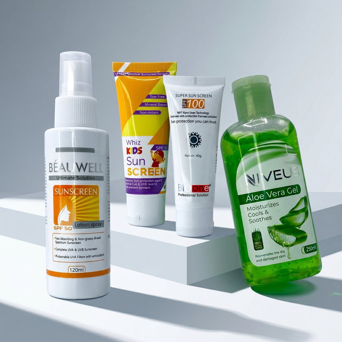 Whiz Beach Ready Kit featuring Beauwell SPF 50 Lotion Spray, Whiz Kids Sunscreen, Bio One SPF 100 Sun Screen, and Niveus Aloe Vera Gel on white pedestal blocks.