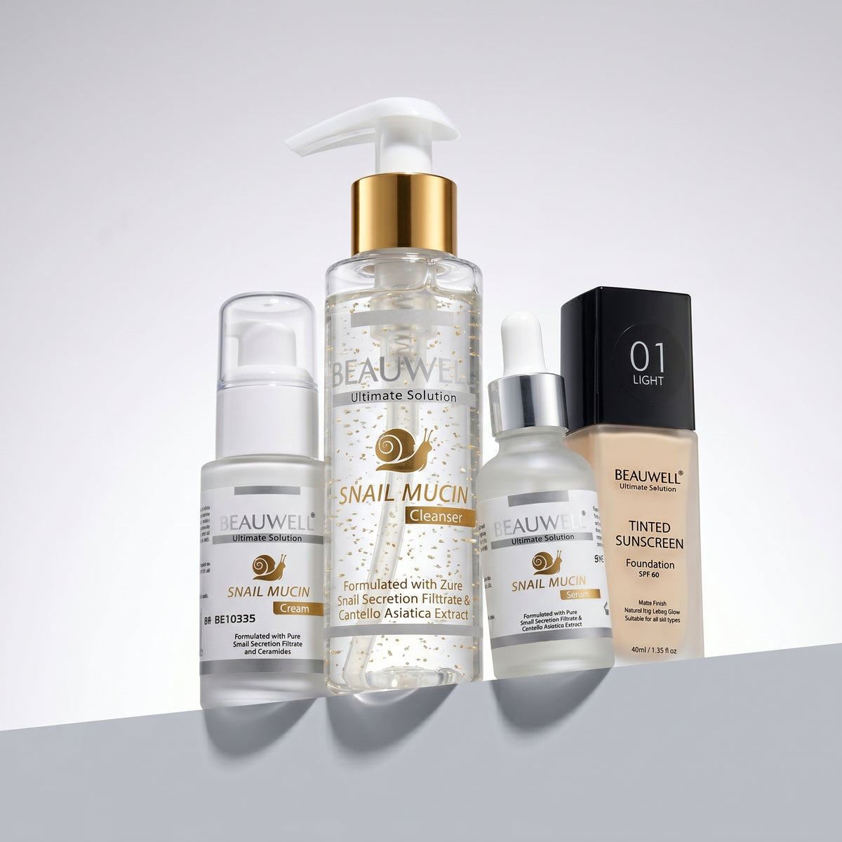 Whiz Glass Skin Kit featuring Beauwell Snail Mucin Cleanser, Snail Mucin Serum, Snail Mucin Cream, and Beauwell Tinted Sunscreen Foundation on white pedestal blocks.