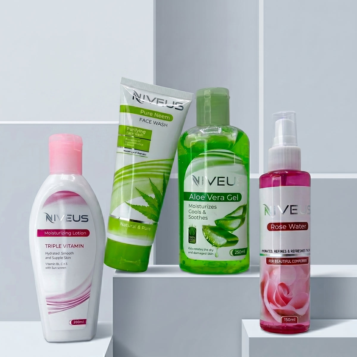Whiz Natural Care Bundle featuring Niveus Triple Vitamin Moisturizing Lotion, Pure Neem Face Wash, Aloe Vera Gel, and Rose Water on white pedestal blocks.